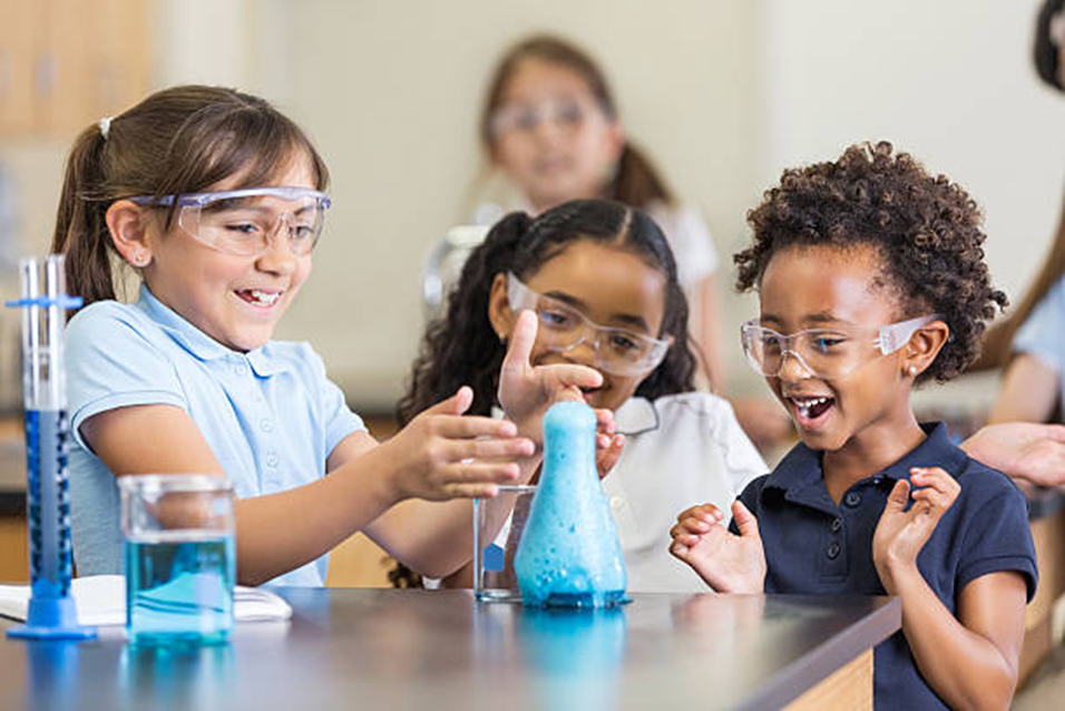 Students laughing as a foaming experiment bubbles over