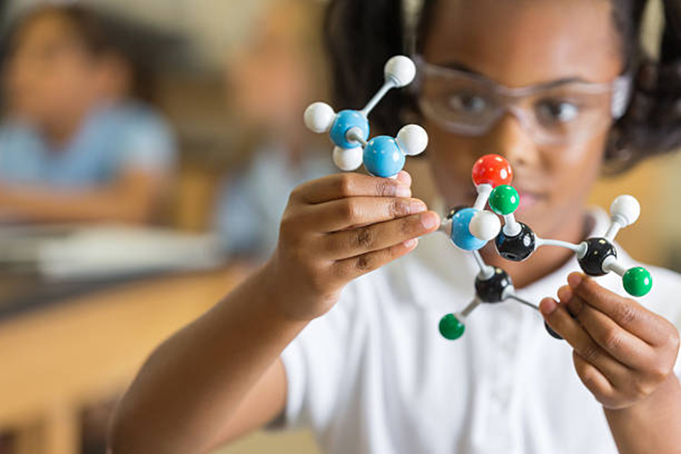A student examining a molecular model